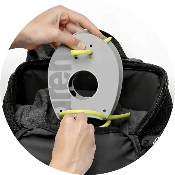 Ett par händer lägger ner handpaddlar i väskan