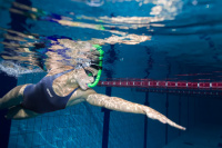 En kvinna simmar under vattnet med snorkeln