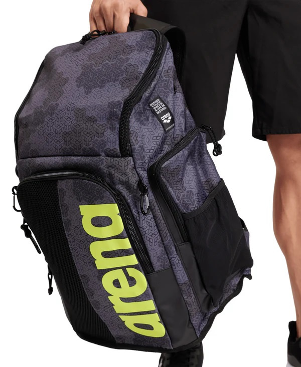 En person håller väskan i handtaget bredvid sina ben