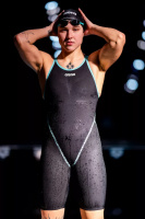 En dam i baddräkten mot en mörk bakgrund