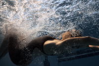 En dam i Impulso tävlingsbaddräkten simmar under vatten