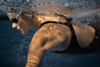 En dam i Impulso tävlingsbaddräkten simmar under vatten