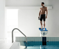 En man i badbyxorna står på en startplatta