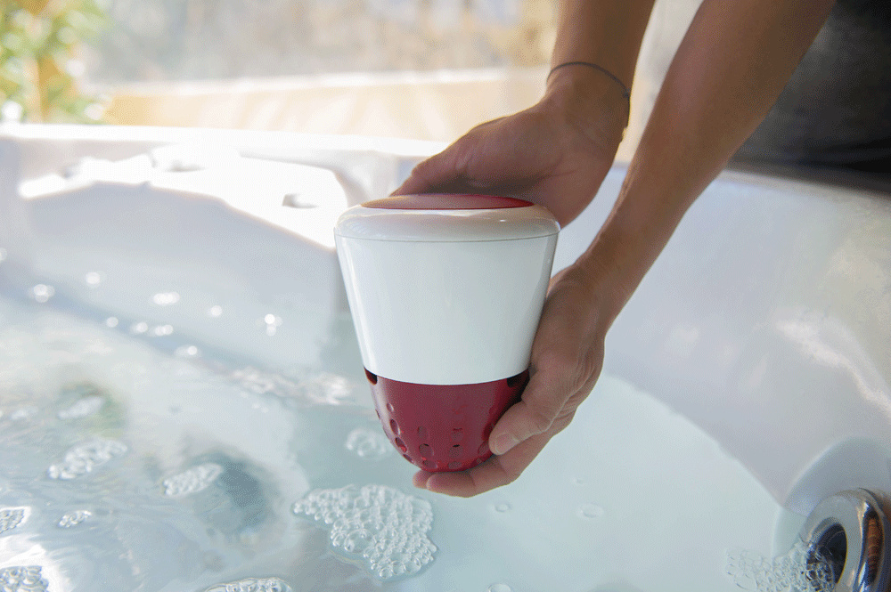 Två händer håller ICO spa ovanför vattenytan