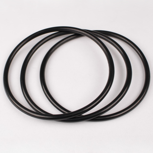 Tre o-ringar mot en ljusgrå bakgrund