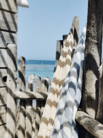 Två handdukar på ett staket vid havet