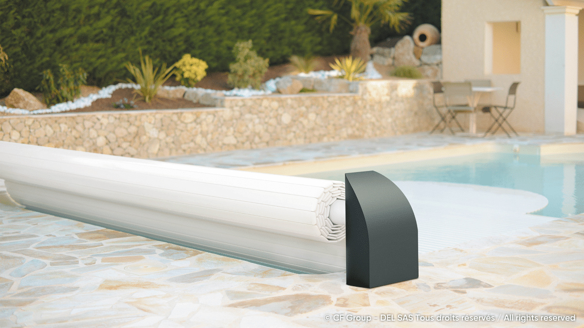 Contura Lamelltäcket i vit PVC halvvägs upprullat i en pool med beige stensarg