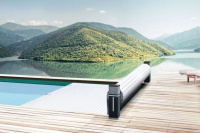 Tixit Lamelltäcke i en pool med träsarg. i bakgrunden syns en sjö och berg