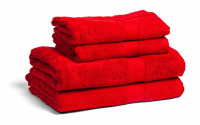 Fyra röda handdukar och badlakan staplade ovanpå varandra mot en vit bakgrund.