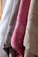 Närbild på handdukarna i vitt, grått, rosa, och sand