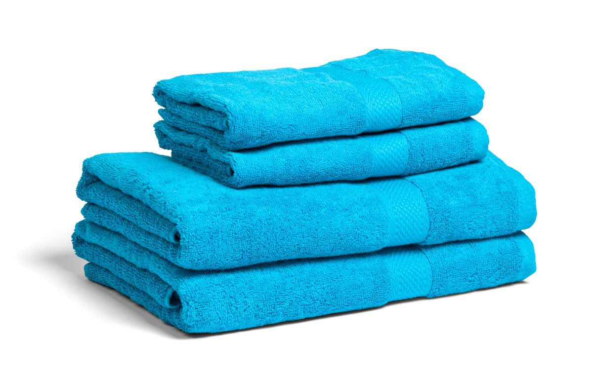 Fyra turkosa handdukar och badlakan staplade ovanpå varandra mot en vit bakgrund.