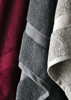 Närbild på handdukarna i rött, mörkgrått, och grått
