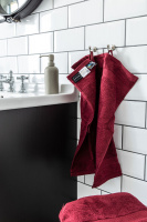 Röda handdukar hängande och liggande i ett badrum