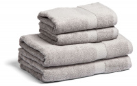 Fyra gråa handdukar och badlakan staplade ovanpå varandra mot en vit bakgrund.