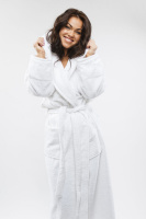 En dam i badrocken med huvan nere