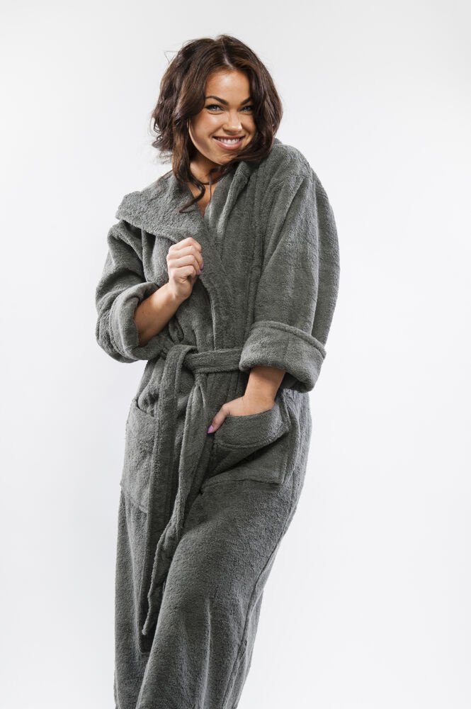 En dam i badrocken med huvan nere