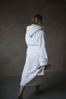 Badrocken i vitt En dam i morgonrocken går bort från kameran