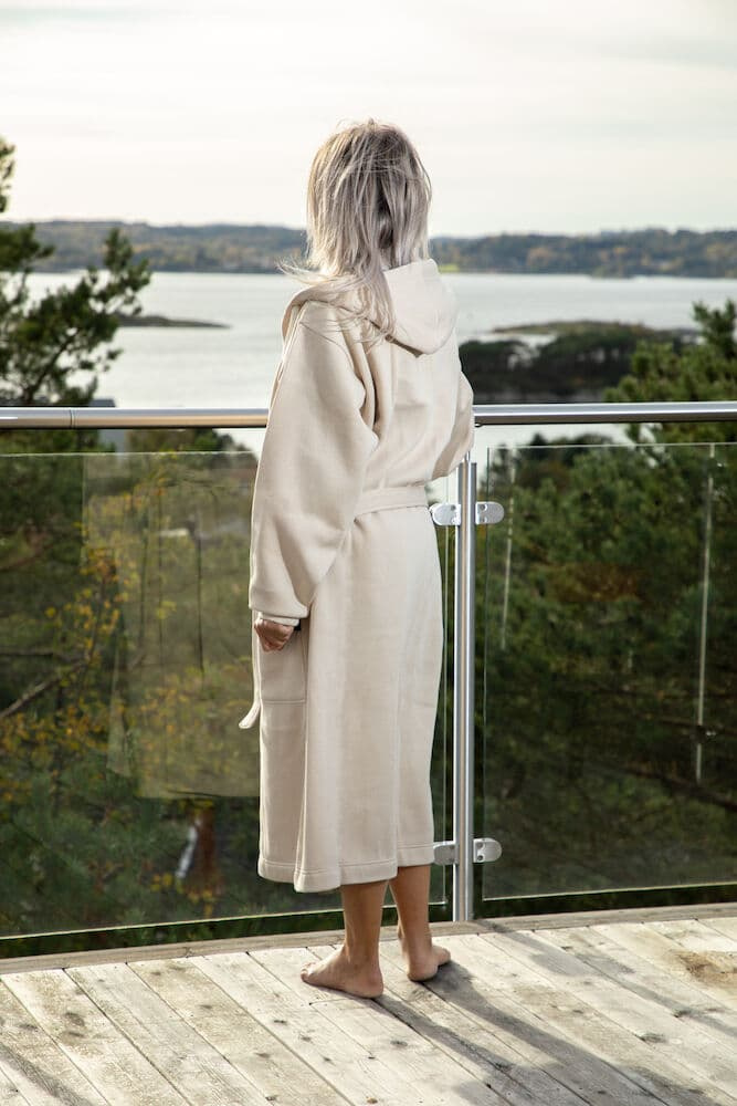 En dam i badrocken med ryggen mot kameran.