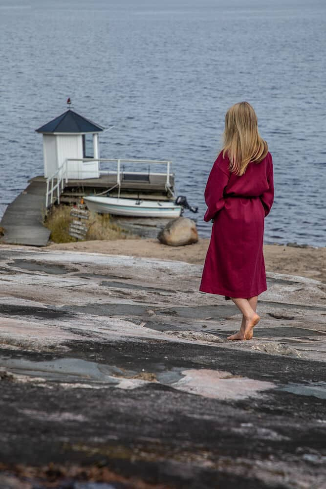 En dam i badrocken med ryggen mot kameran.