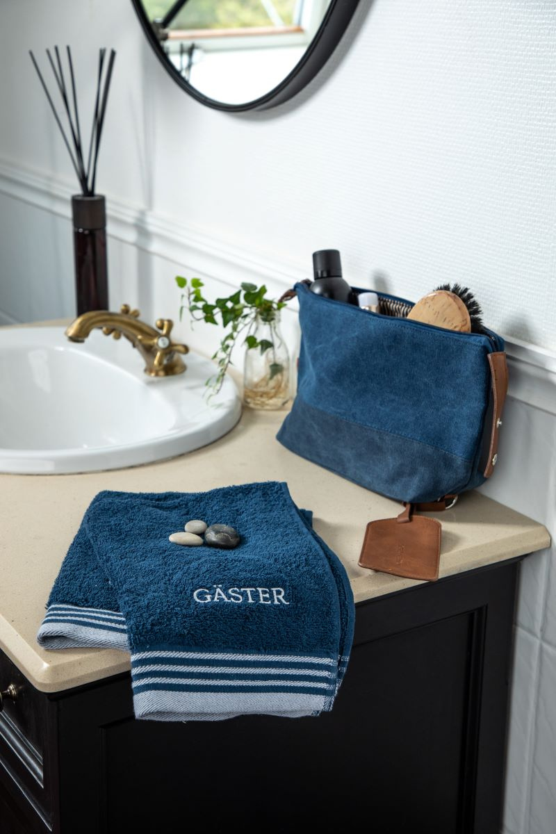 Gästhanddukarna i marin på sidan av ett handfat