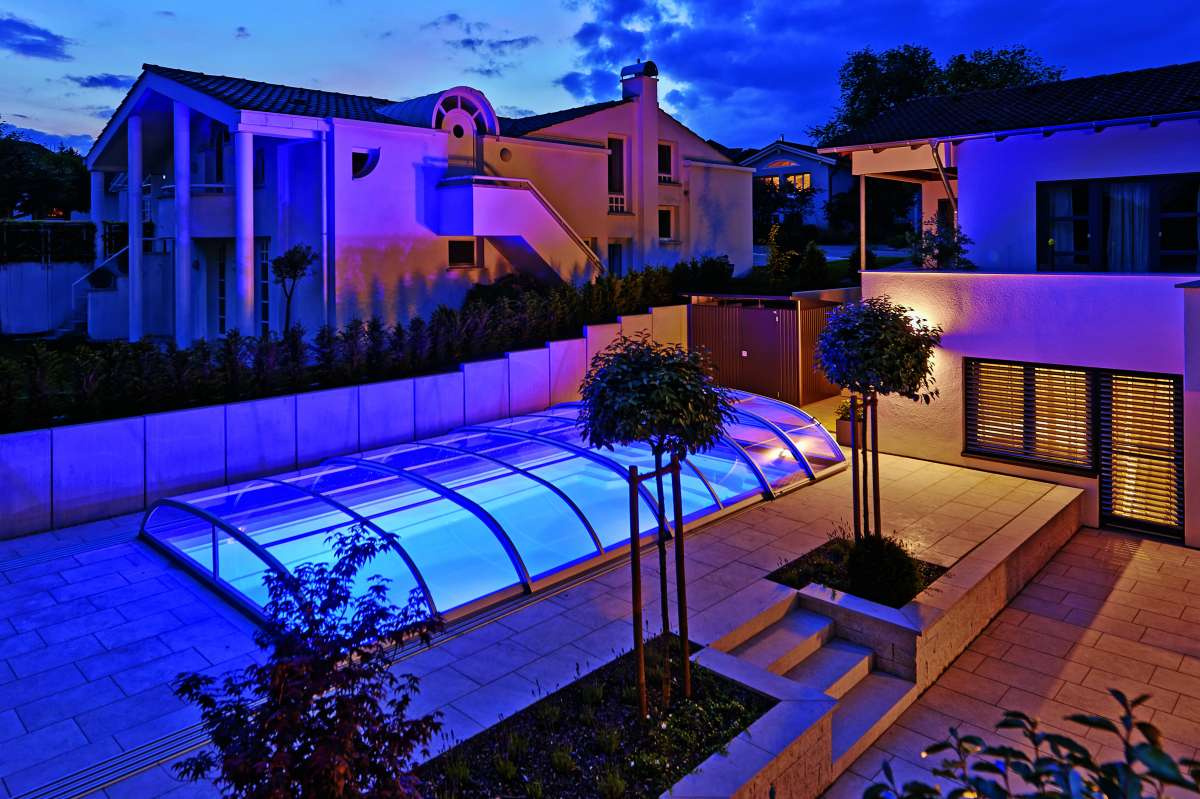 Pooltaket Nova Comfort över en upplyst pool på natten