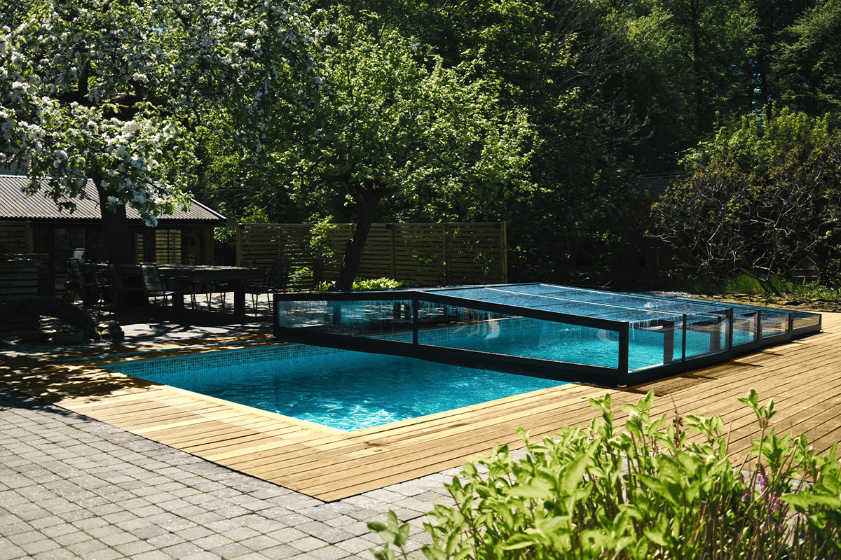 Pooltaket halvöppnat över en pool med en trä och stensarg