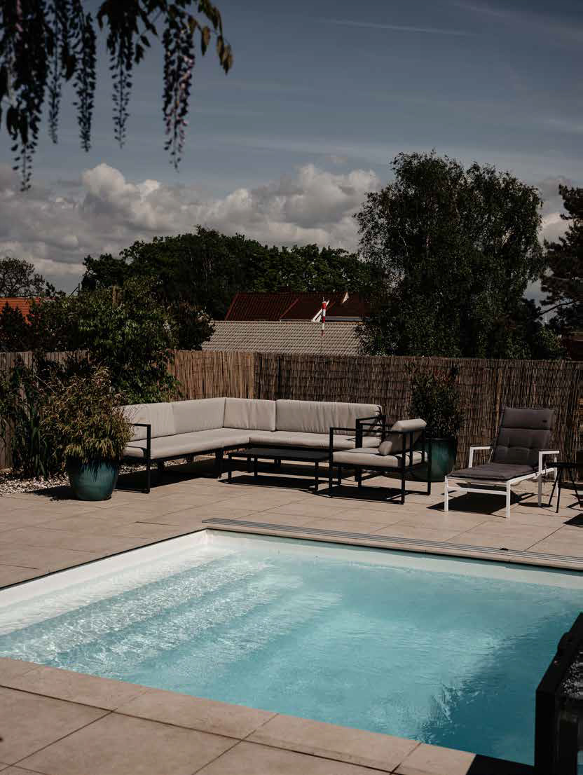 Helgaveltrappan i en färdig pool med en soffgrupp i bakgrunden