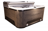 En annan modell i Warm Walnut med ett grått lock Spabadet med ett halvöppet lock mot en vit bakgrund