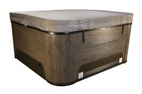 Spabadet i Warm Walnut med ett grått lock Spabadet med stängt grått lock mot en vit bakgrund