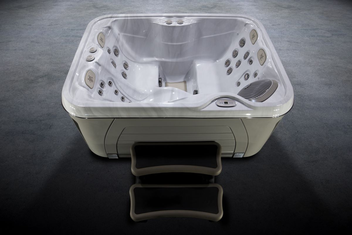 Spabadet sett ovanifrån mot en grå bakgrund och med en trappa framför