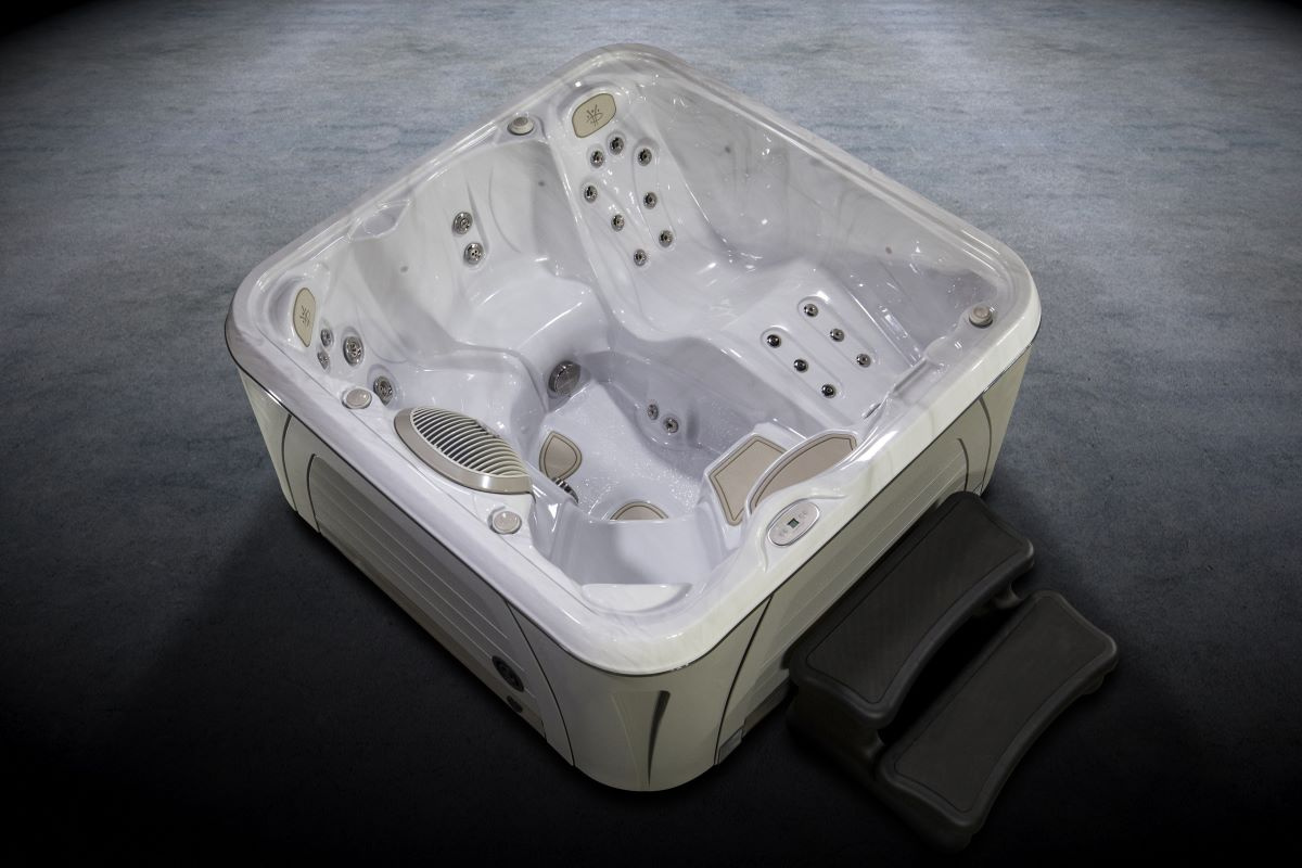 Spabadet sett ovanifrån mot en grå bakgrund och med en trappa framför