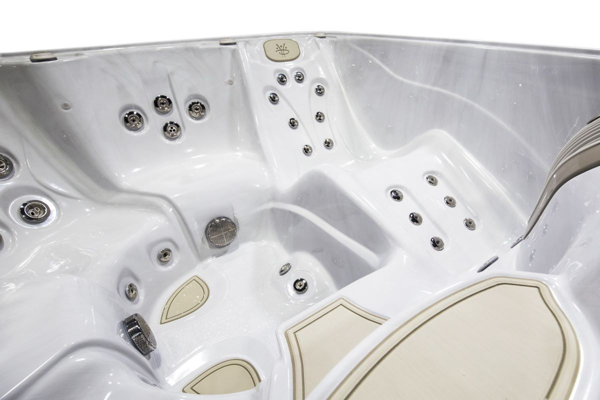 Närbild på spabadets interiör med trappsteg och liggdel