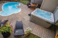 Spabad Serenity 5900 Spabadet på en uteplats bredvid ett hus och en pool