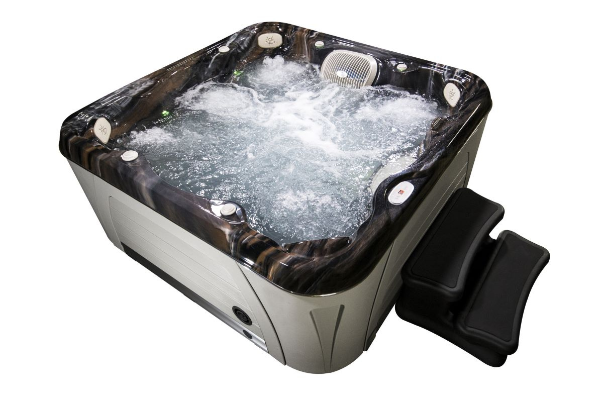 Spabadet fyllt med vatten sett snett ovanifrån mot en vit bakgrund