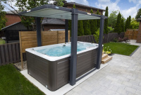 Swimspabadet med ett Covana-skydd Swimspabadet i en trädgård med ett höjt Covana Skydd