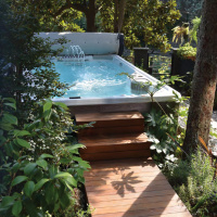 Spabadet med ett rullock Spabadet omringat av växter med ett öppet rullock