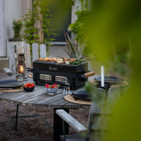 Bordsgrill Kamado Sumo Hibachi Bordsgrillen på ett dukat bord utomhus