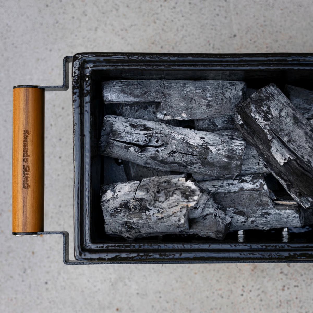 Närbild på grillen ovanifrån med nytt kol i 