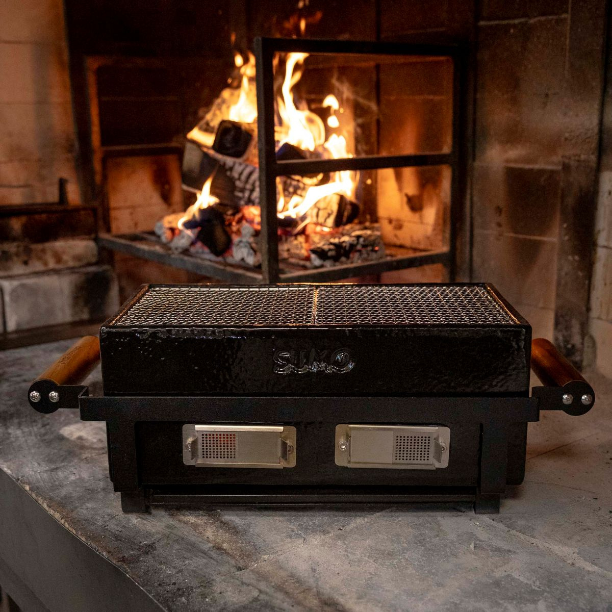 Bordsgrillen framför en eldstad