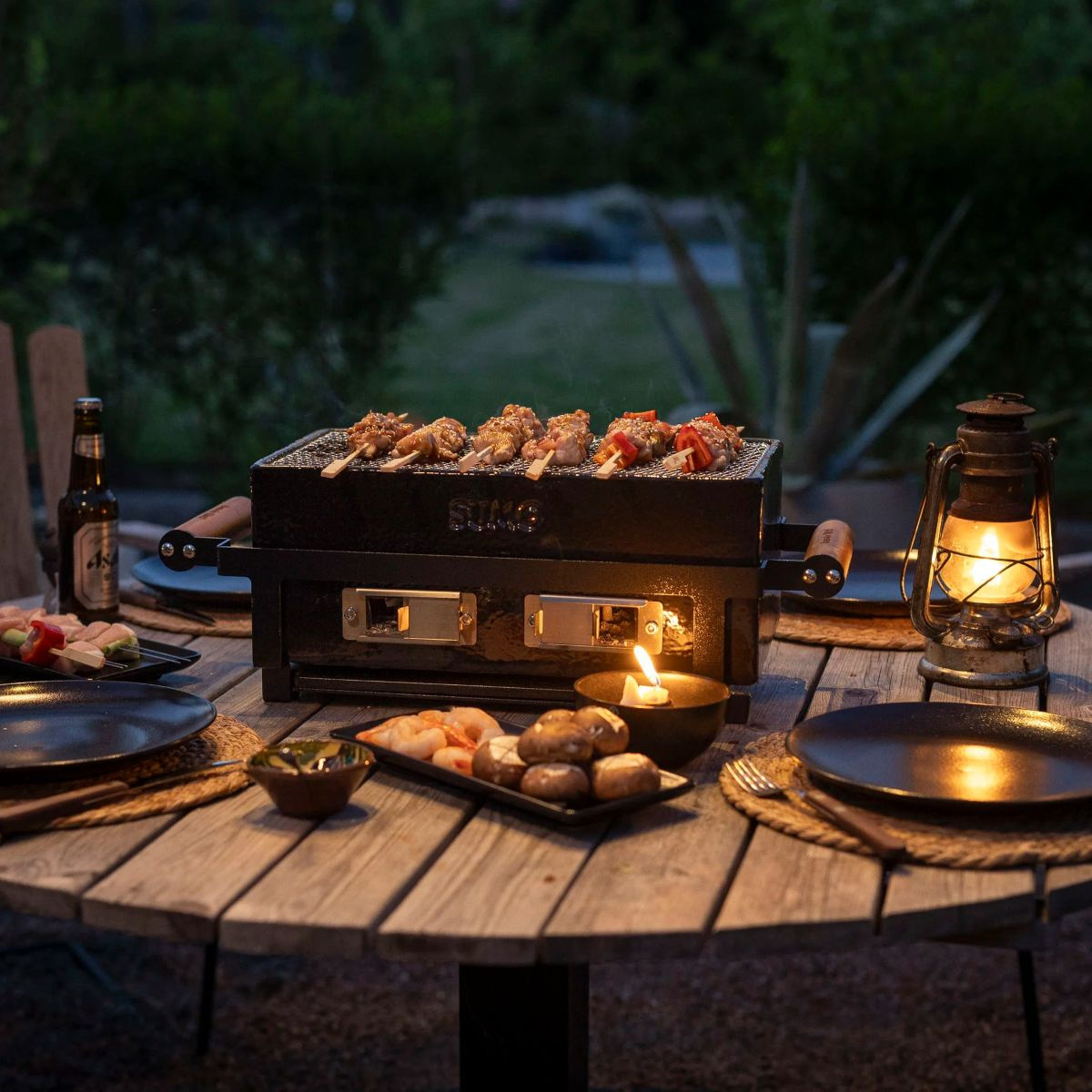Bordsgrillen på ett dukat bord utomhus