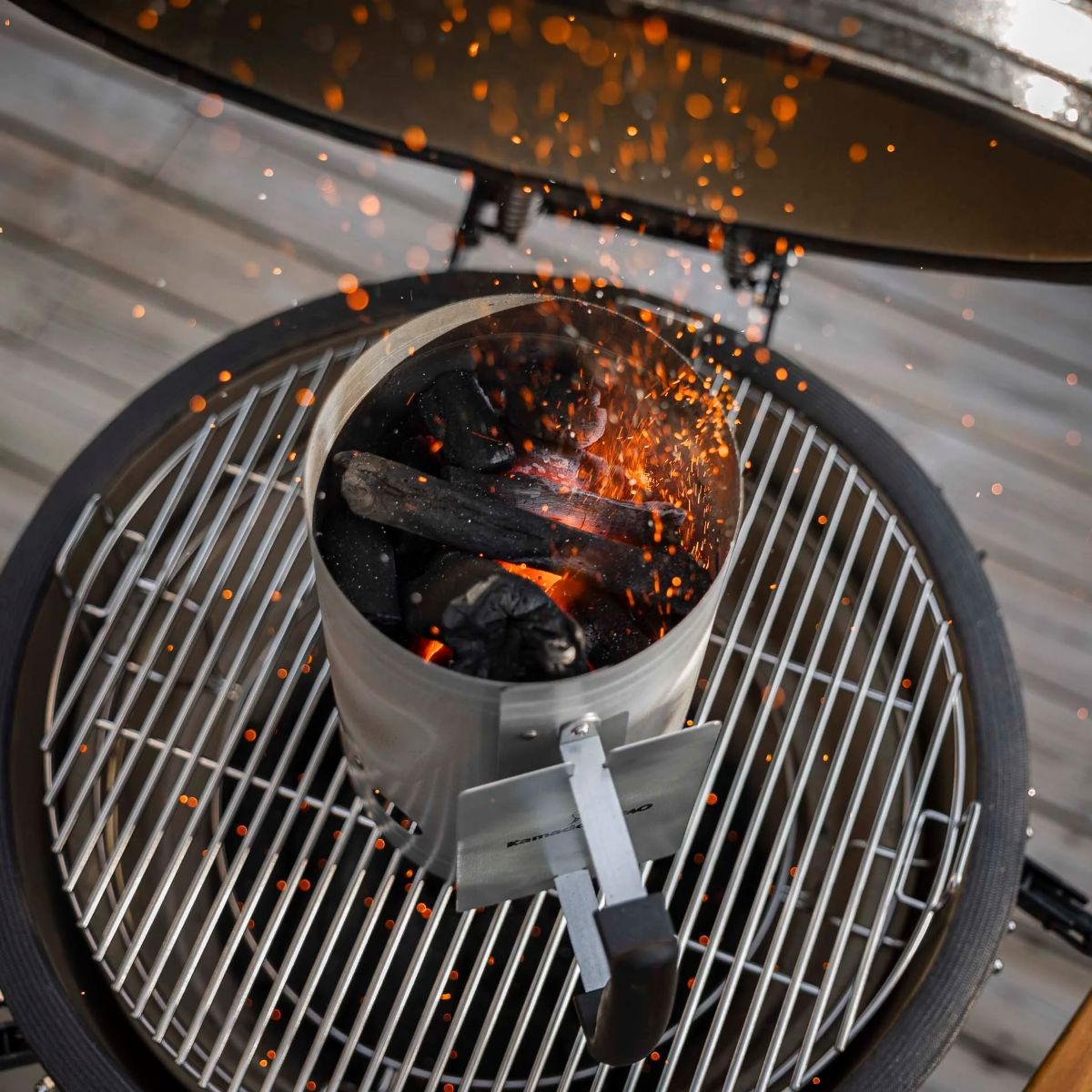 Tändaren fylld med brinnande kol stående på en grill