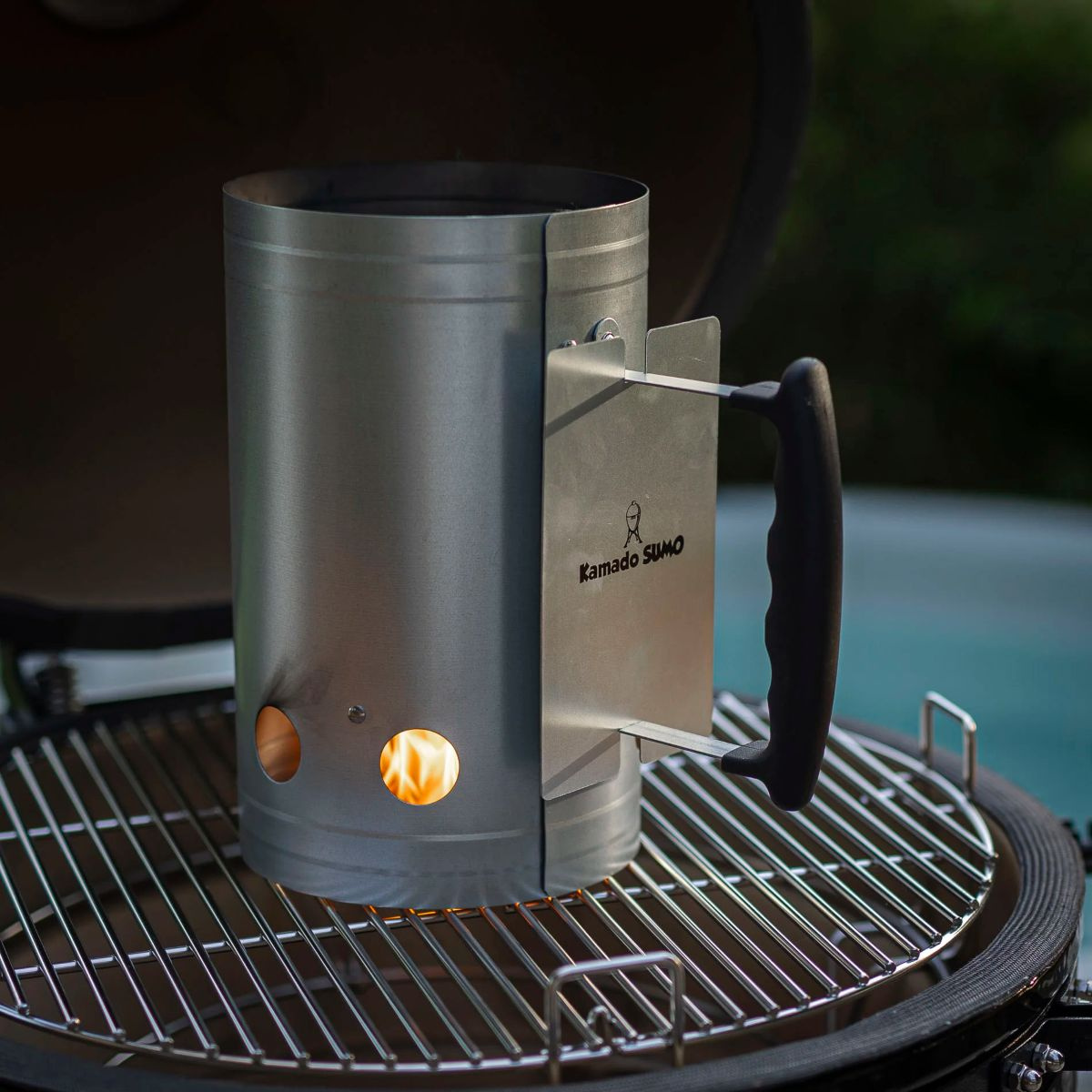 Tändaren fylld med brinnande kol stående på en grill