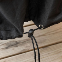 Med spänne nertill för tätare skydd Närbild på dragspännet nertill på skyddet