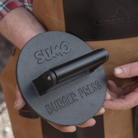 Cast Iron Burger Press En hand håller hamburgarpressen