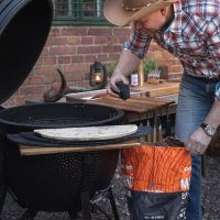 Grillkol Marabu Charcoal, 9 kg, 3-pack En man lyfter en kolbit från påsen till grillen