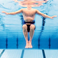 Aqua Bebelt Flytbälte - 80 kg En man har på sig bältet när han är i en pool