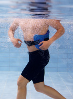 En man har på sig bältet när han joggar i en pool