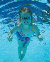 En flicka med guppy glasögonen simmar under vatten