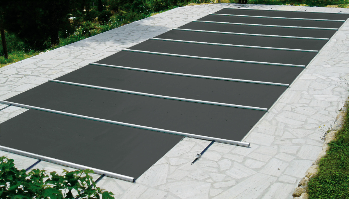 Poolskyddet i antracit helt utrullat över en pool