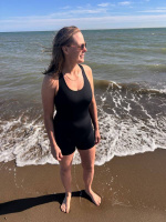 En dam i baddräkten sedd framifrån utomhus vid havet